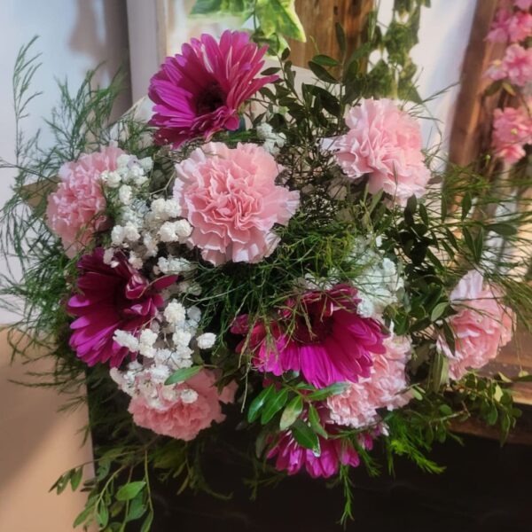 Ramo de flores variadas con gerberas magenta y clavellinas rosadas entre verdes decorativos y gypsophila, de Floristería Azahar 33.