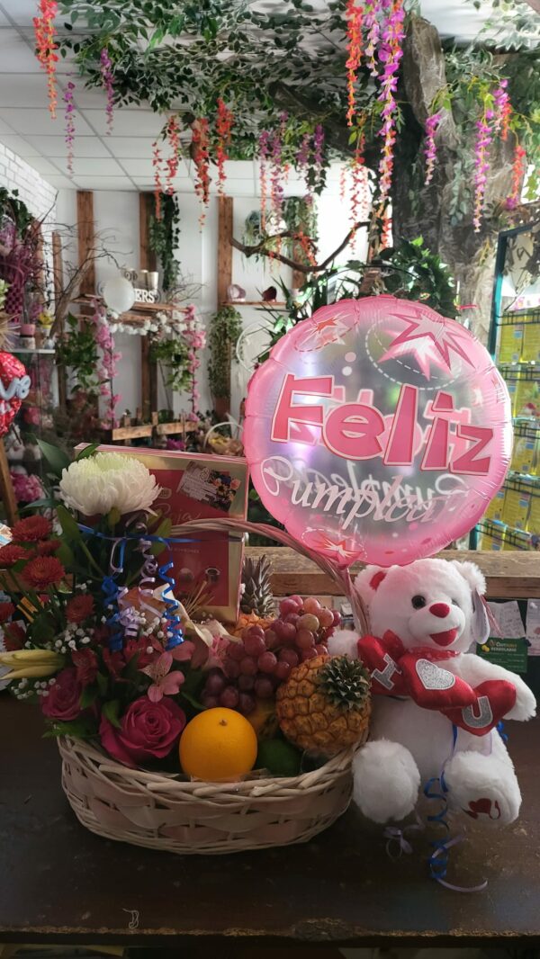 Cesta de regalo con flores, frutas, bombones, un globo de 'Feliz Cumpleaños' y un osito de peluche de Floristería Azahar 33